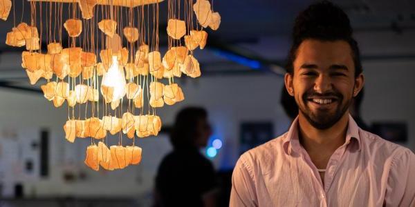 Zane Mitchell-Almoustapha with his digi-fab lamp, Sacral Chakra Chandelier