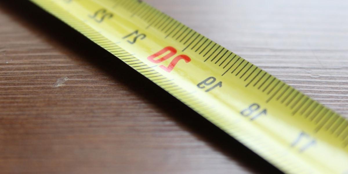 yellow tape measure extended, laying flat on table top