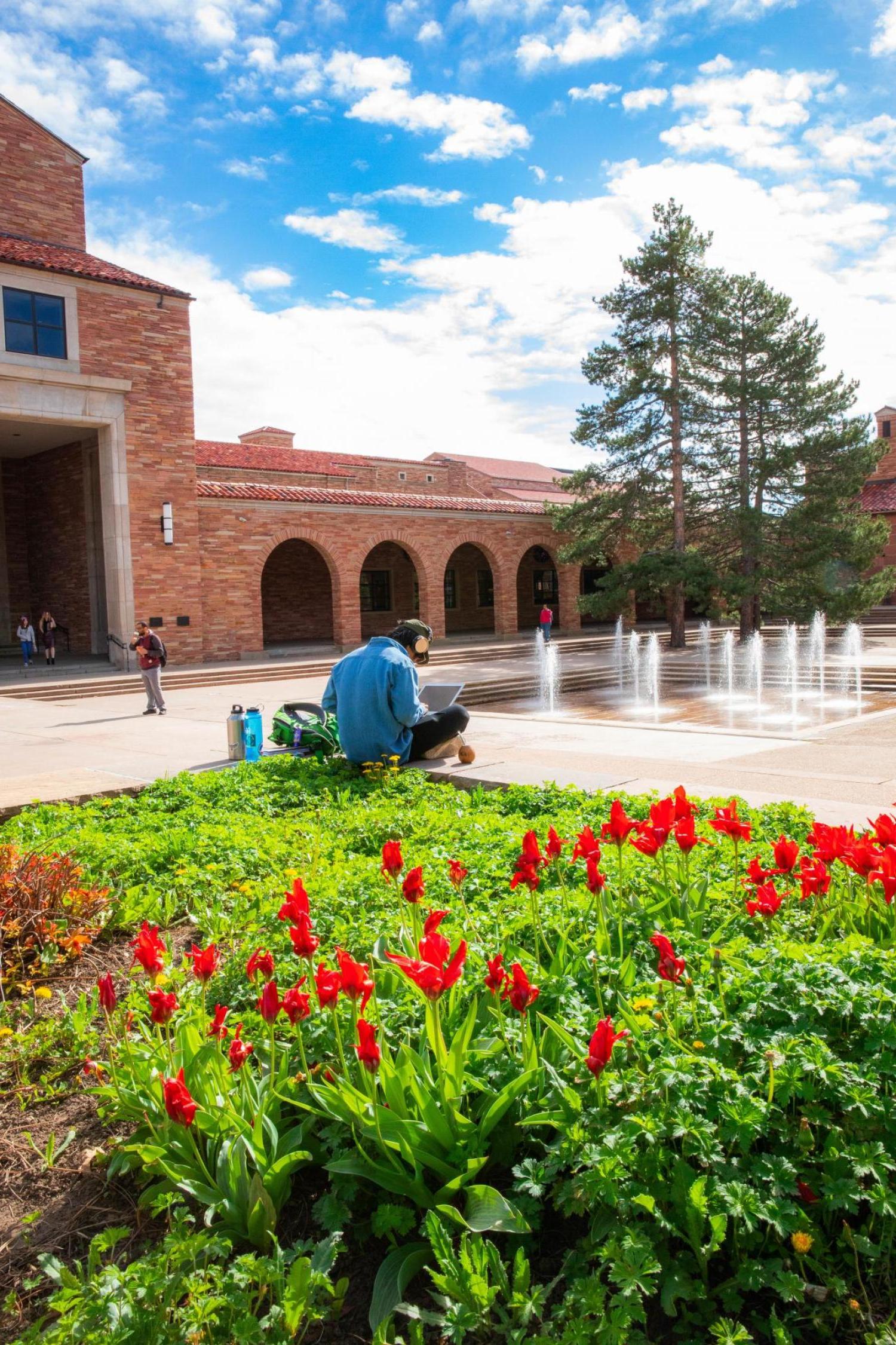 Student outside the UMC fountains in the spring