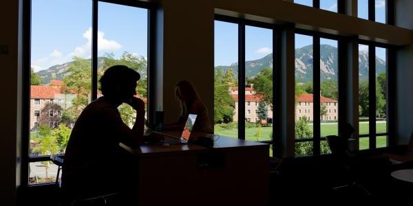 Silhouette of a student studying on campus