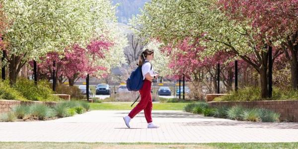 a student walking across campus in spring