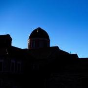 Silhouette of a building on campus in front of a bluebird sky