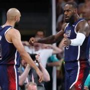 LeBron James and Derrick White interact on the basketball court, arms extended and facing each other.