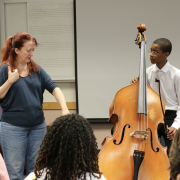 instructor working with student playing an upright bass