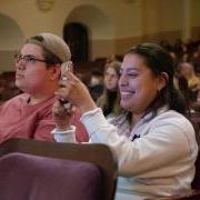 Audience member takes a photo during a Conference on World Affairs session